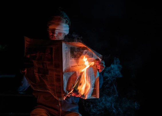 Lector leyendo diario que se está prendiendo fuego