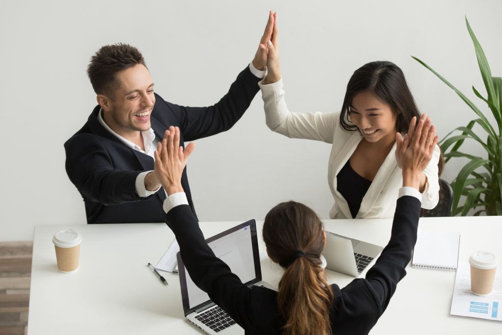 emocionado-equipo-multirracial-tomados-mano-dando-alta-celebrando-exito-cinco-scaled.jpg