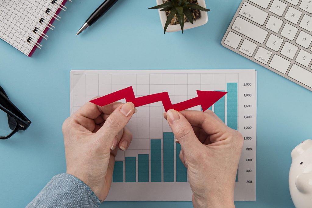 top-view-business-items-with-growth-chart-hands-holding-arrow-scaled.jpg